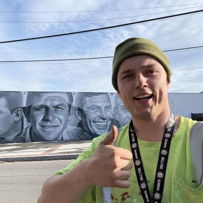 Billy in a safety vest giving a thumbs up at the track